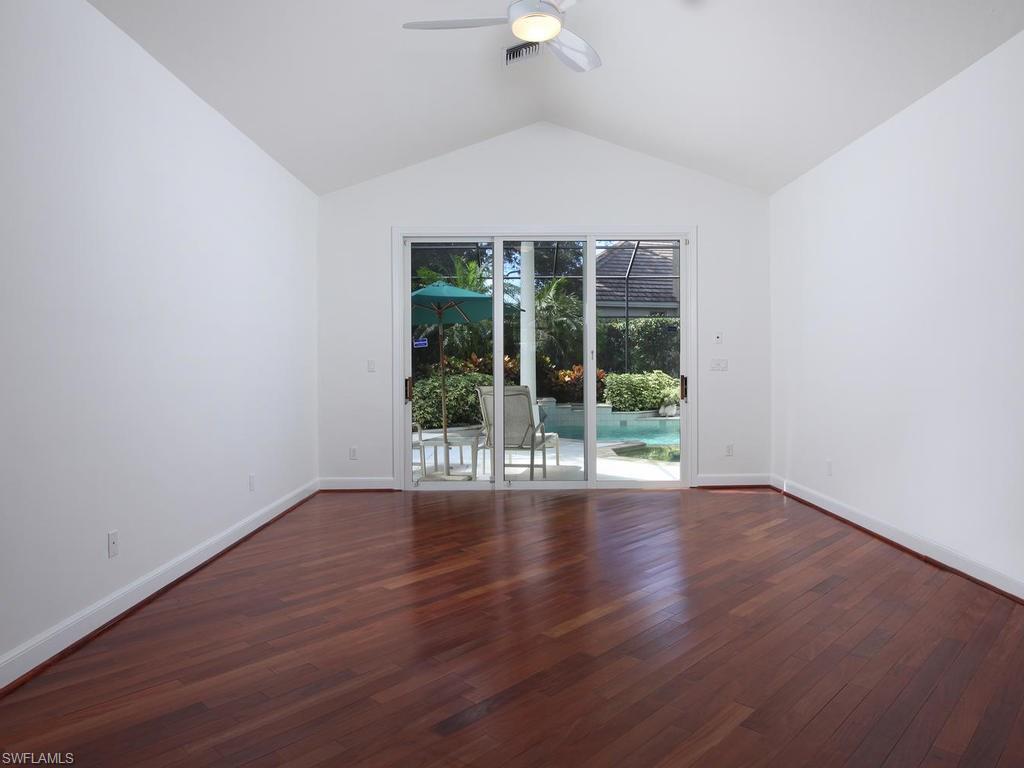 720 Turkey Oak Lane Naples, FL 34108 - Photo 9 of 17 wooden floor in an empty room with a window