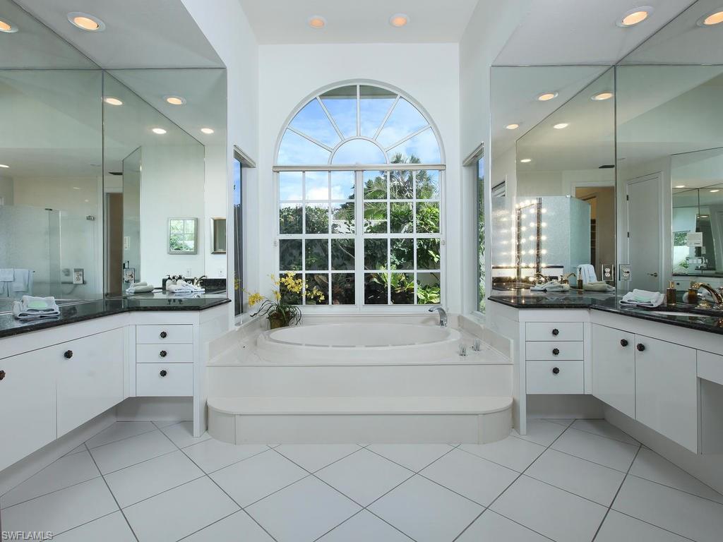 720 Turkey Oak Lane Naples, FL 34108 - Photo 10 of 17 a large white bathroom with a large tub sink vanity granite and a