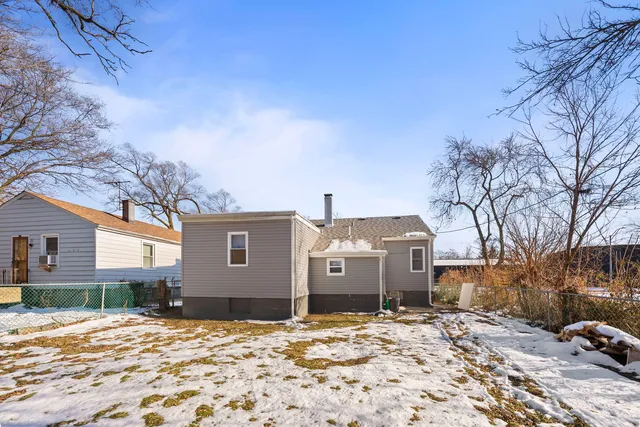 a front view of a house with a yard covered in snow