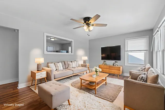 a living room with furniture a flat screen tv and a window