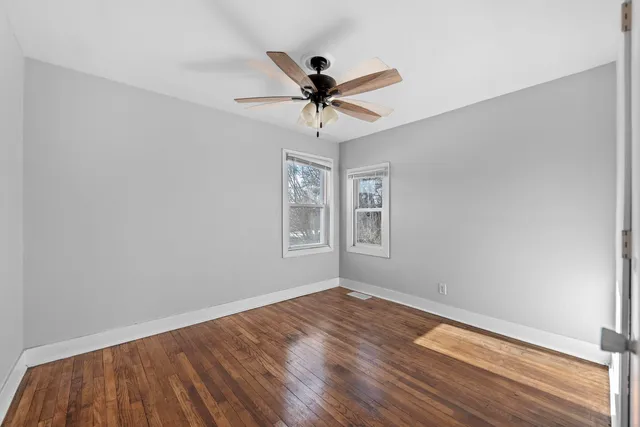 wooden floor in an empty room with a window