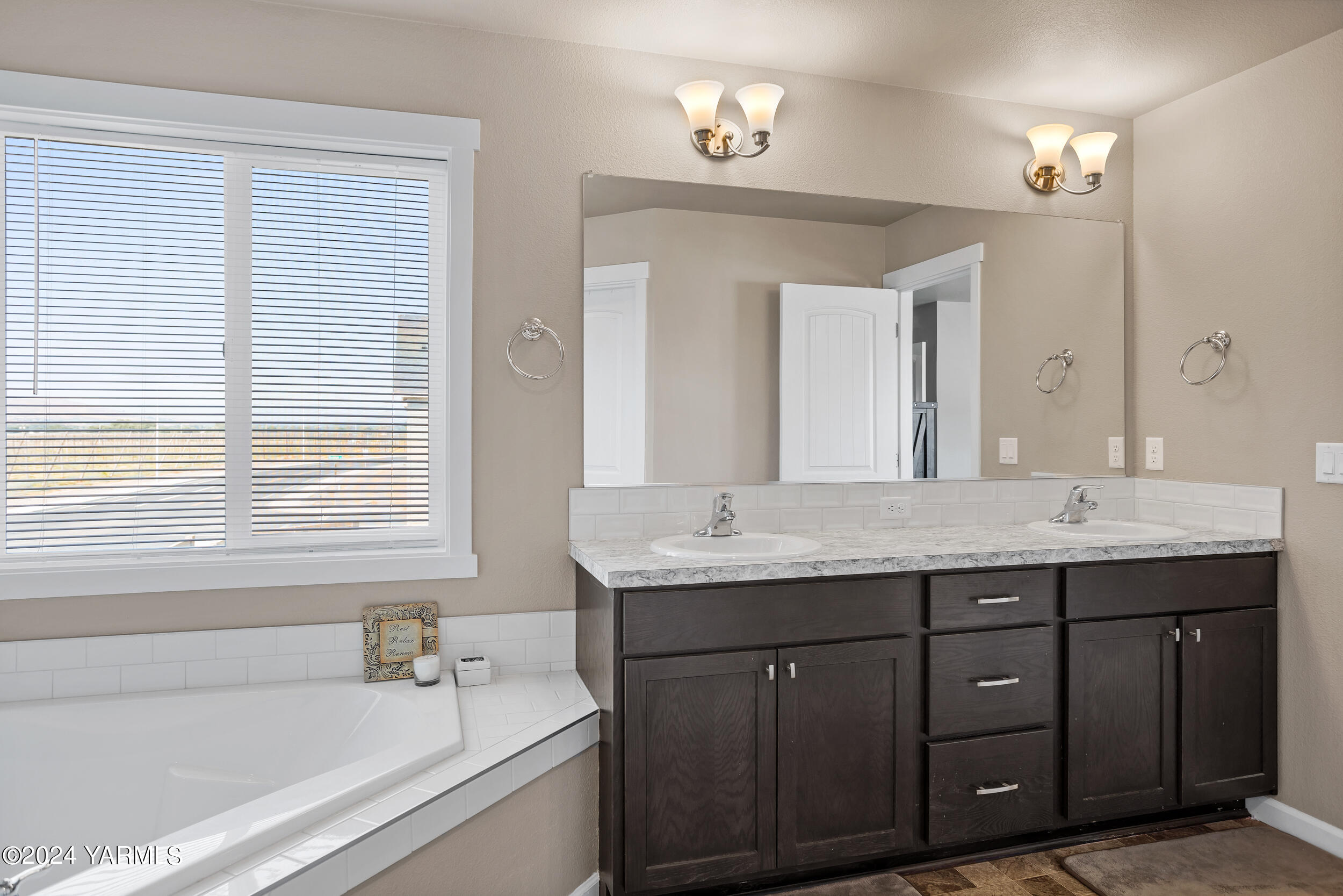 2100 Amber Loop Yakima, WA 98901 - Photo 14 of 25 a bathroom with a granite countertop sink a large mirror a bathtub and next to a window