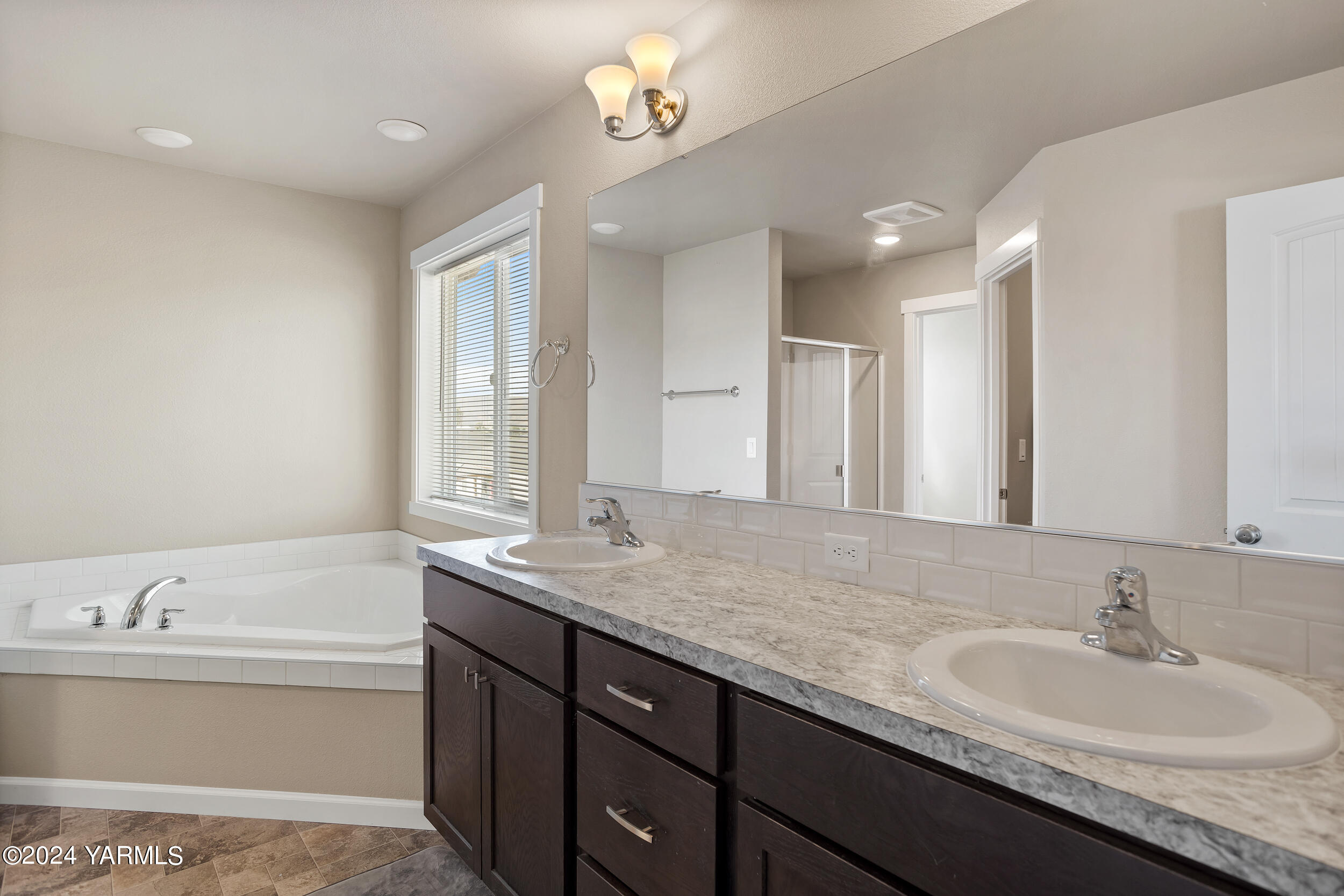 2100 Amber Loop Yakima, WA 98901 - Photo 15 of 25 a bathroom with a granite countertop sink a bathtub a mirror and vanity