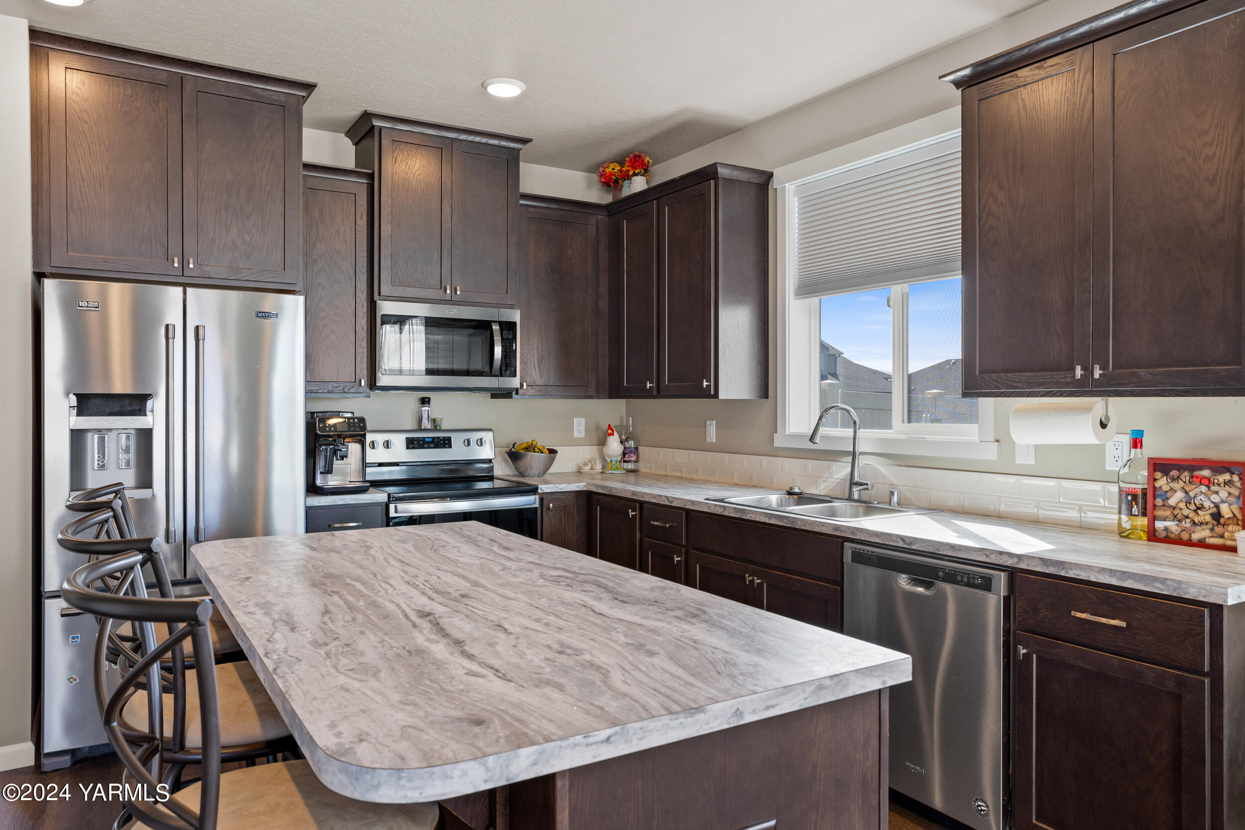 2100 Amber Loop Yakima, WA 98901 - Photo 4 of 25 a kitchen with a sink a stove a refrigerator cabinets and a kitchen island