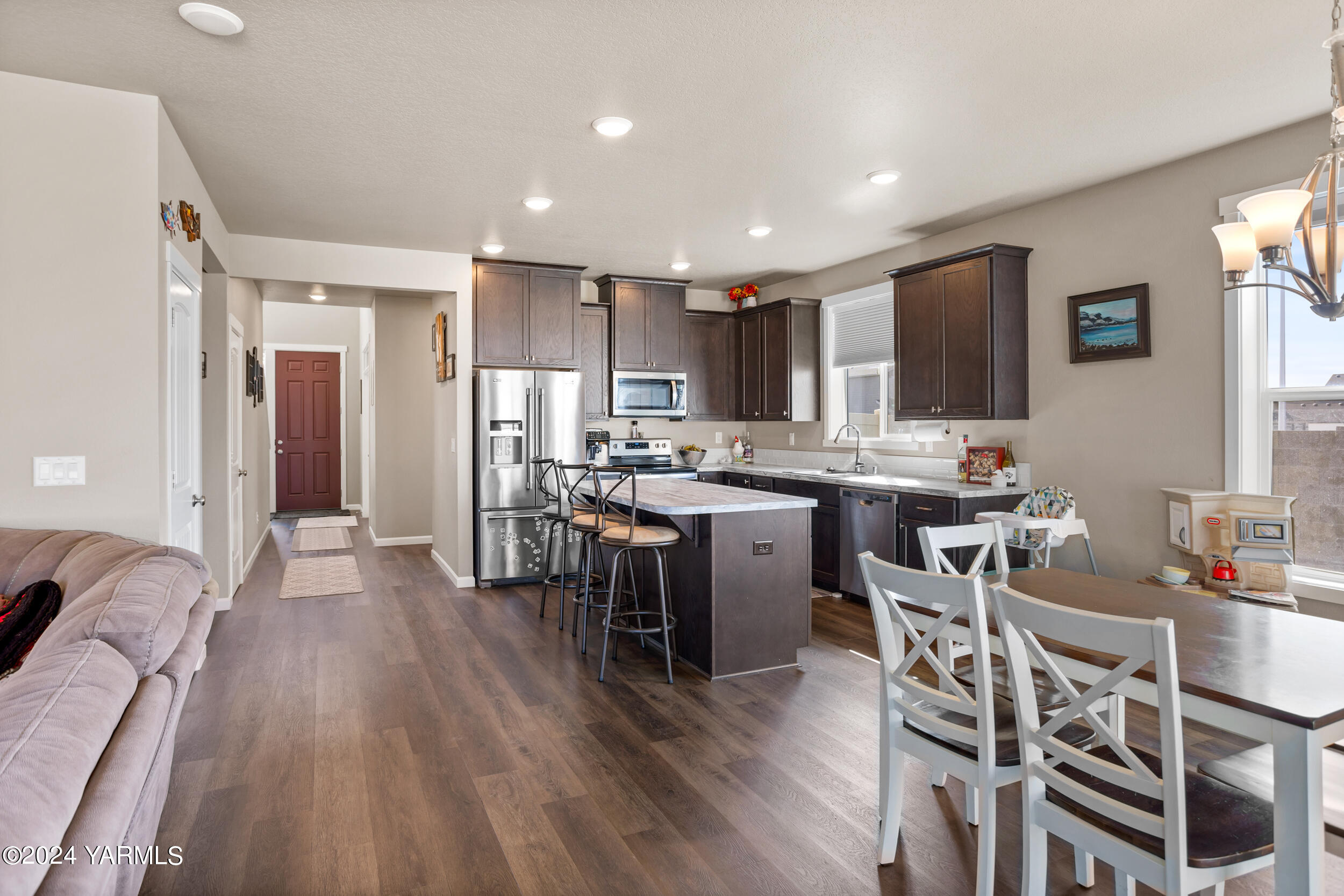 2100 Amber Loop Yakima, WA 98901 - Photo 8 of 25 a open dining room with stainless steel appliances kitchen island granite countertop a table chairs and a refrigerator