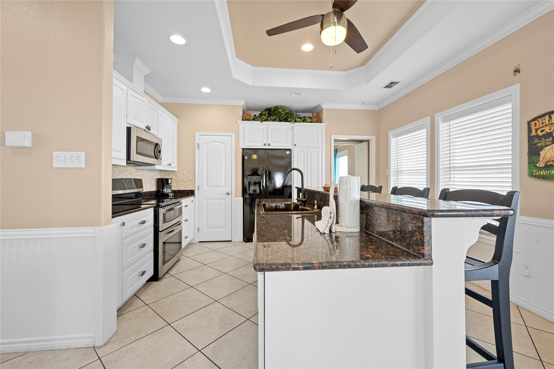 740 Copano Cove Road Rockport, TX 78382 - Photo 18 of 35 a kitchen with granite countertop a refrigerator a stove a sink a dining table and chairs with wooden floor