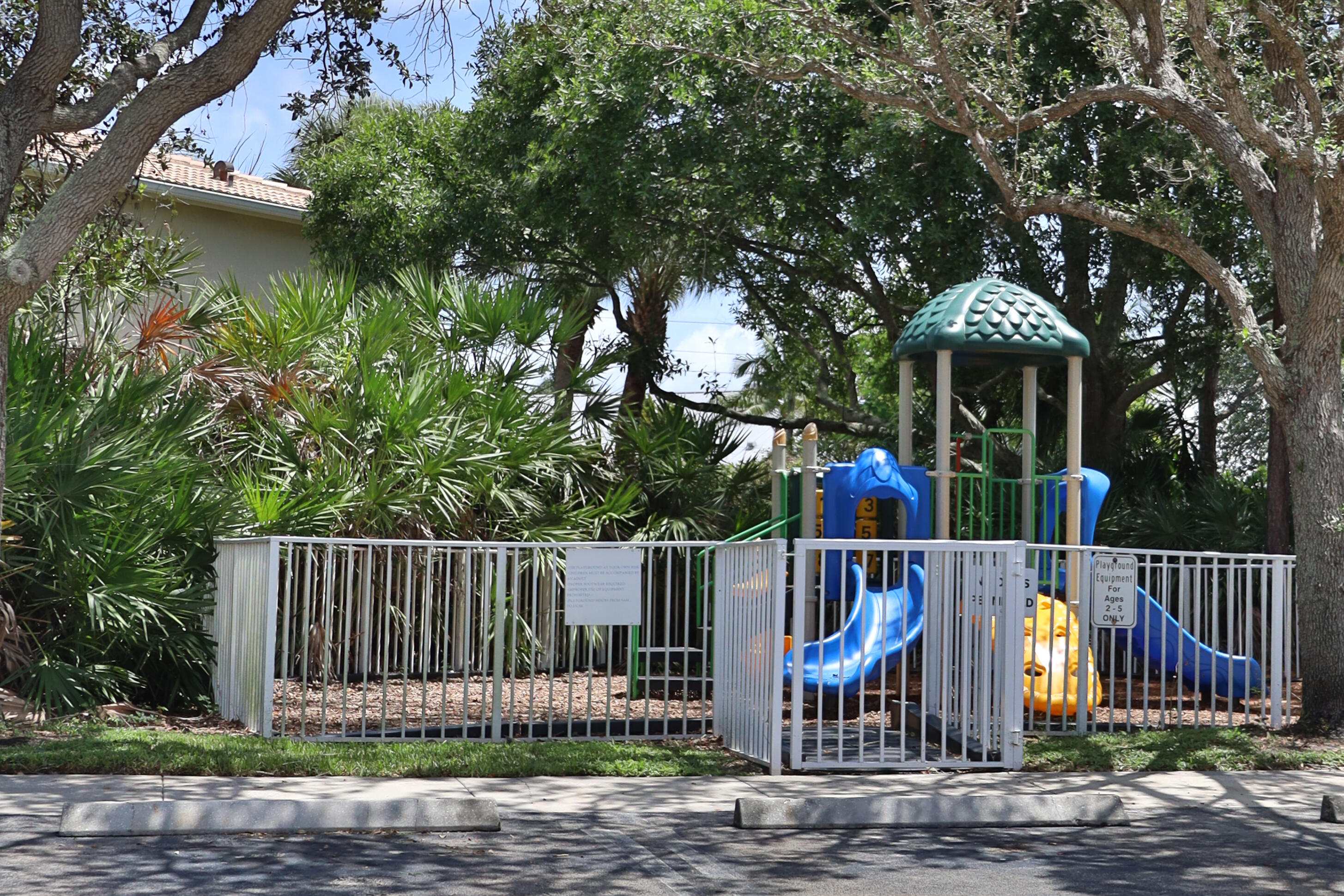 334 Timberwalk Trail Jupiter, FL 33458 - Photo 35 of 51 a view of a street with a large tree and wooden fence