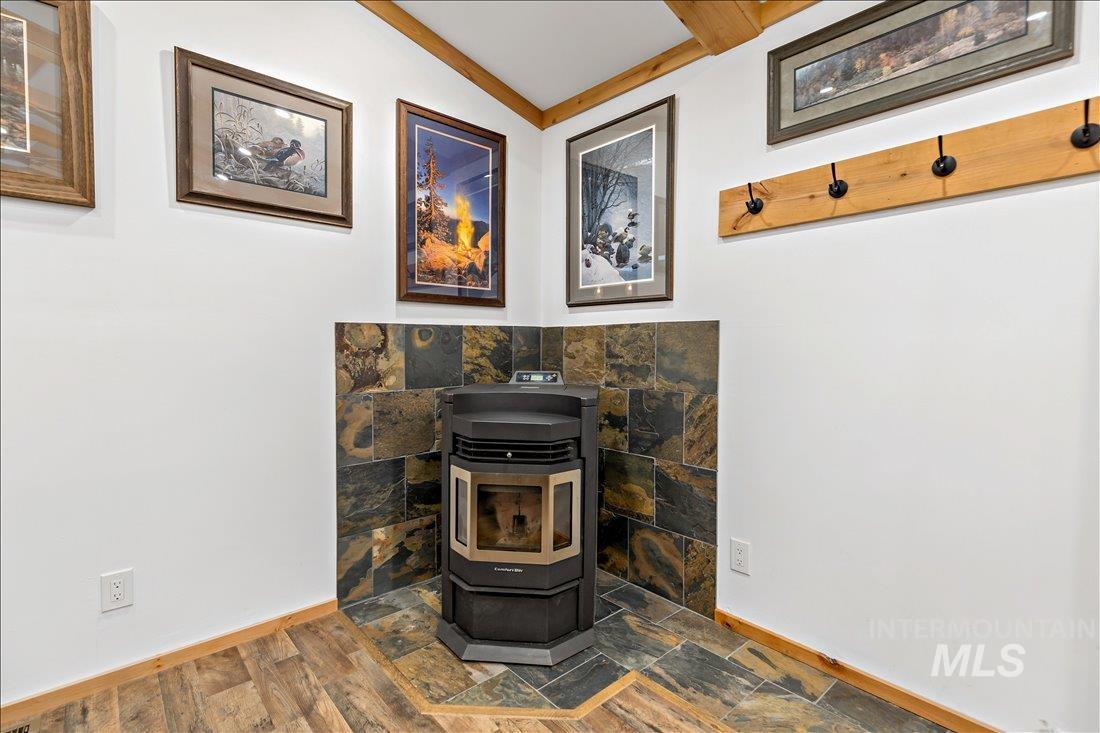 79 Sunset Loop Cascade, ID 83611 - Photo 8 of 44 Corner pellet stove with a multi-toned stone tile surround and coordinating floor pad