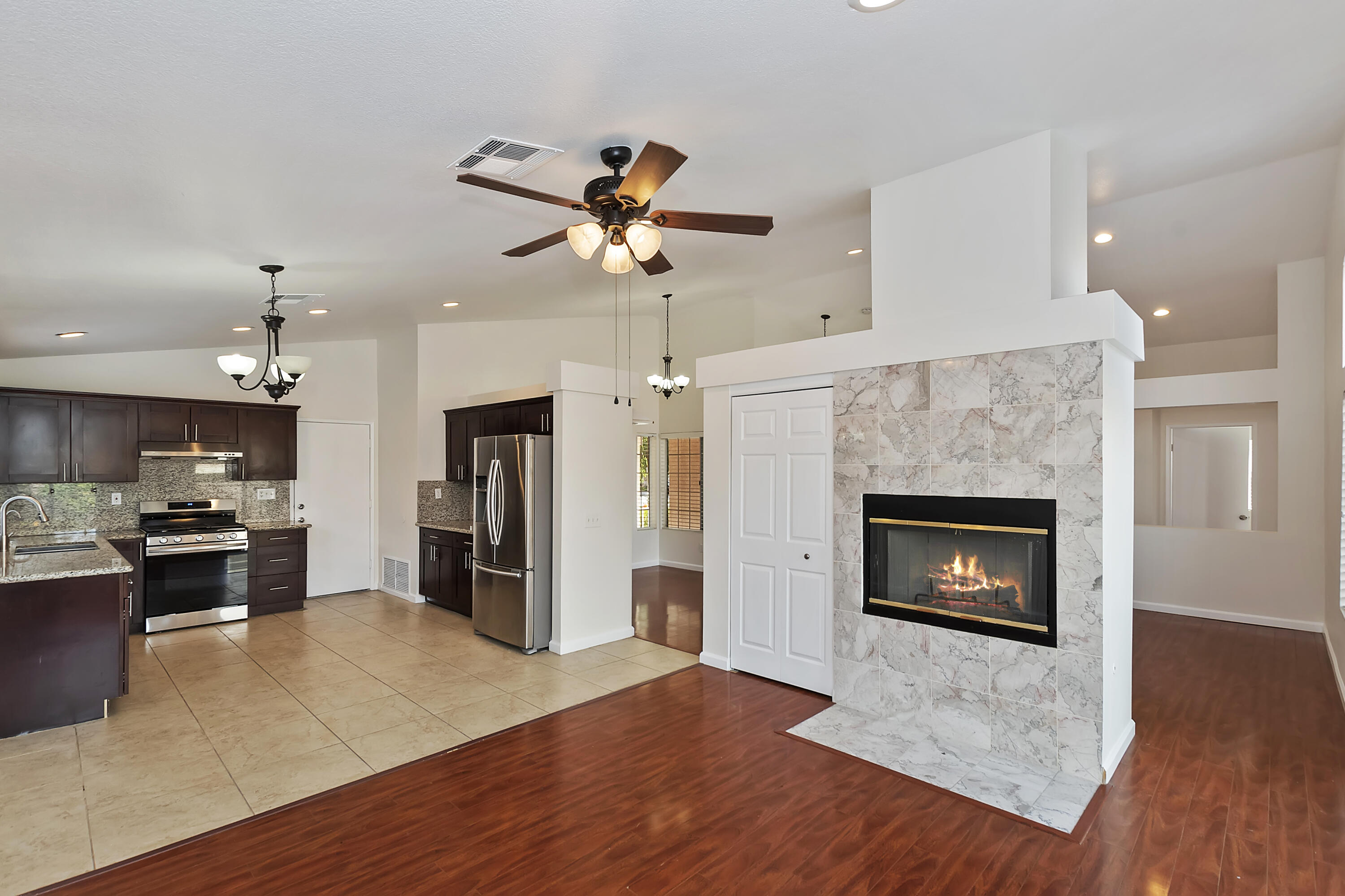 80472 Suncastle Road Indio, CA 92201 - Photo 12 of 32 a living room with stainless steel appliances furniture a fireplace and a kitchen view