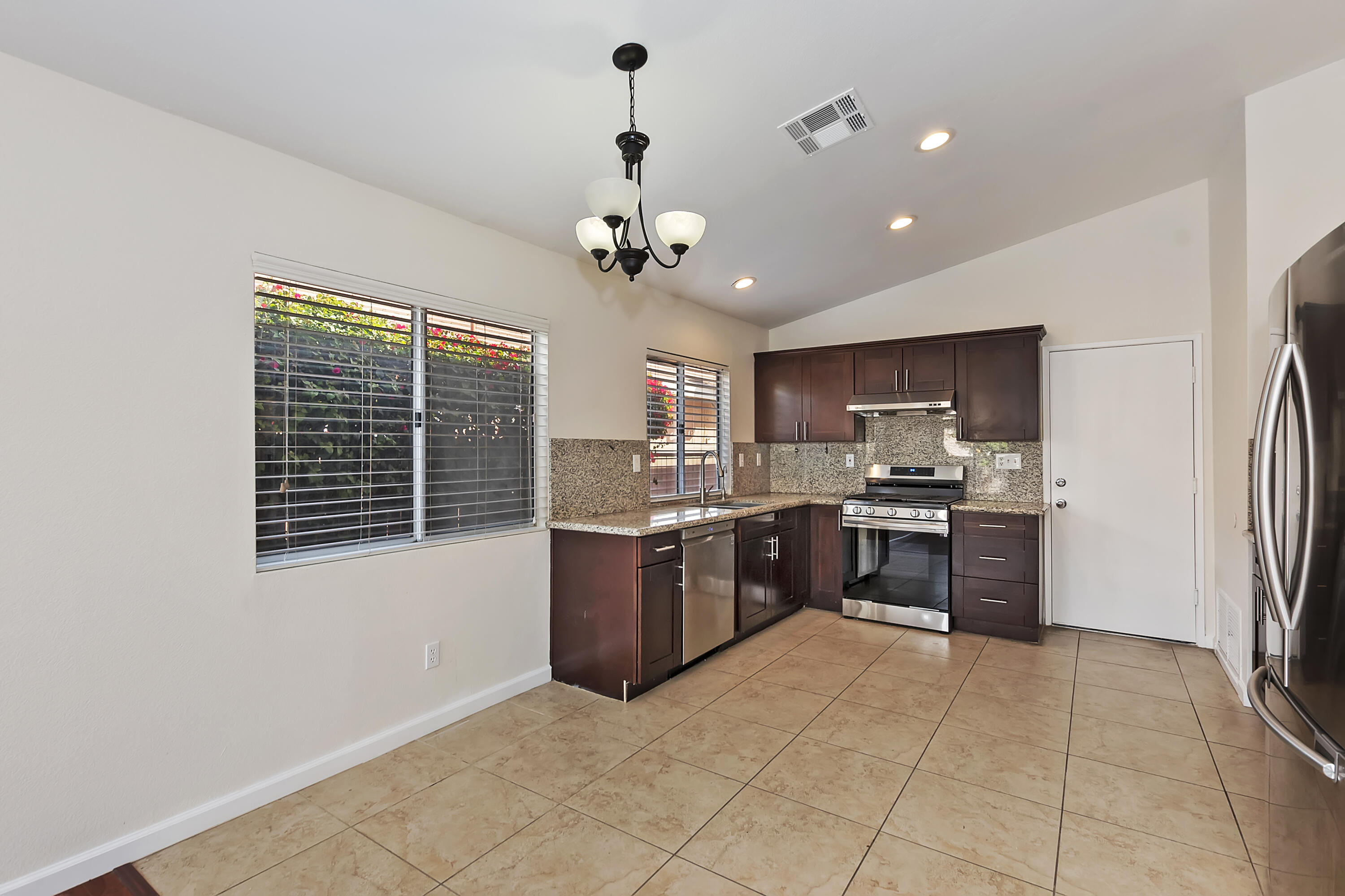 80472 Suncastle Road Indio, CA 92201 - Photo 13 of 32 a large kitchen with a stove a refrigerator and a kitchen island