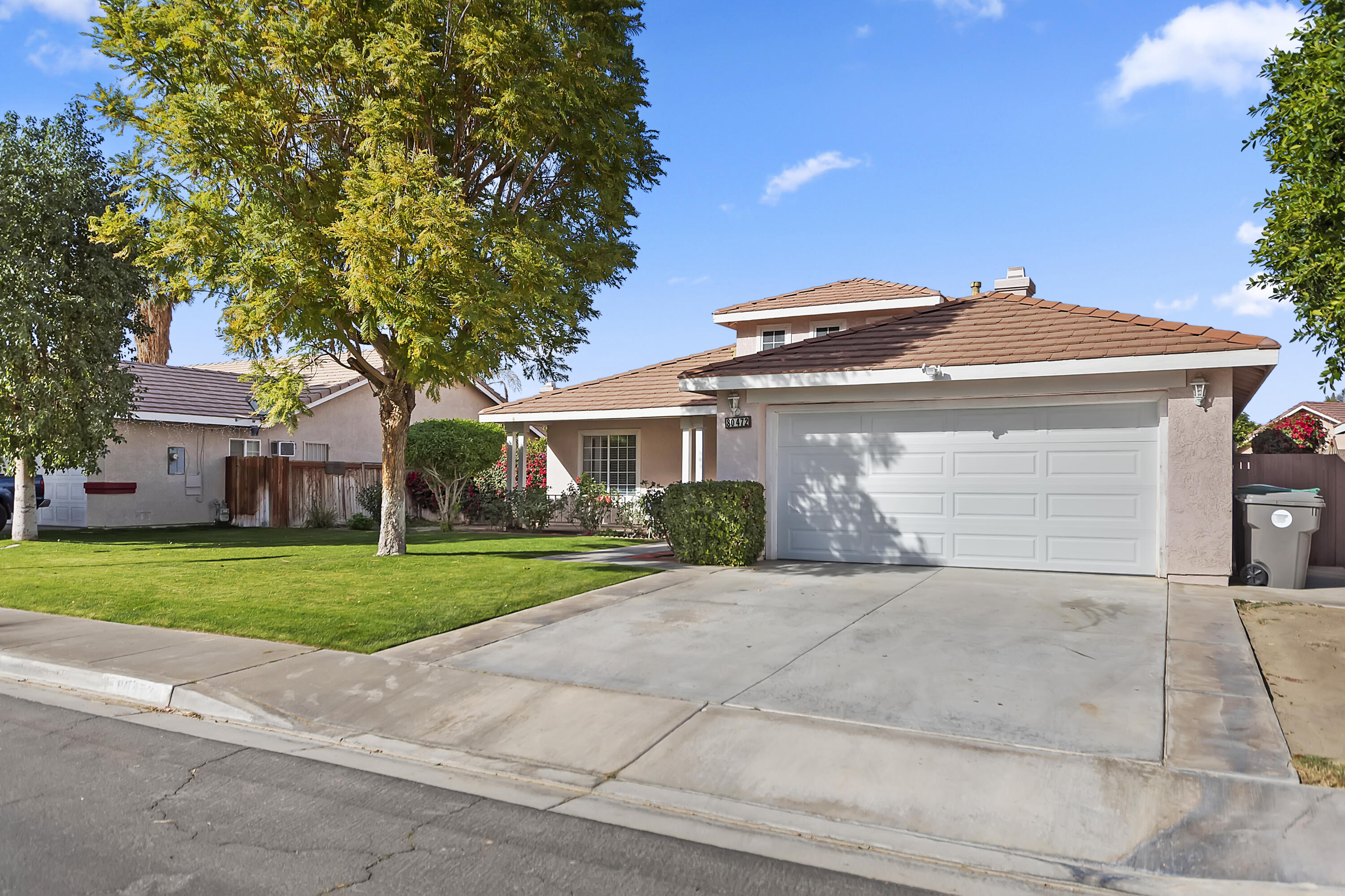 80472 Suncastle Road Indio, CA 92201 - Photo 2 of 32 a front view of a house with a yard and garage