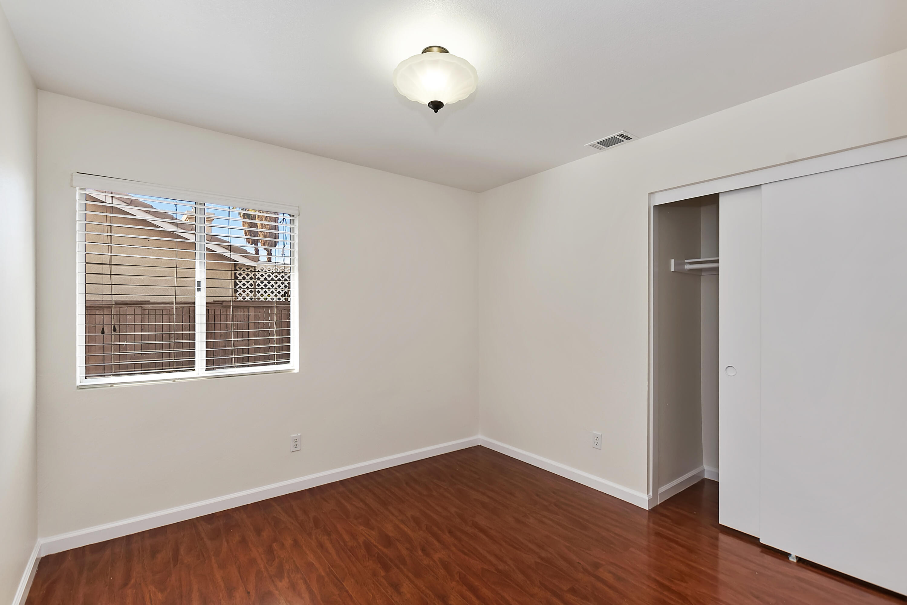 80472 Suncastle Road Indio, CA 92201 - Photo 22 of 32 an empty room with wooden floor and windows
