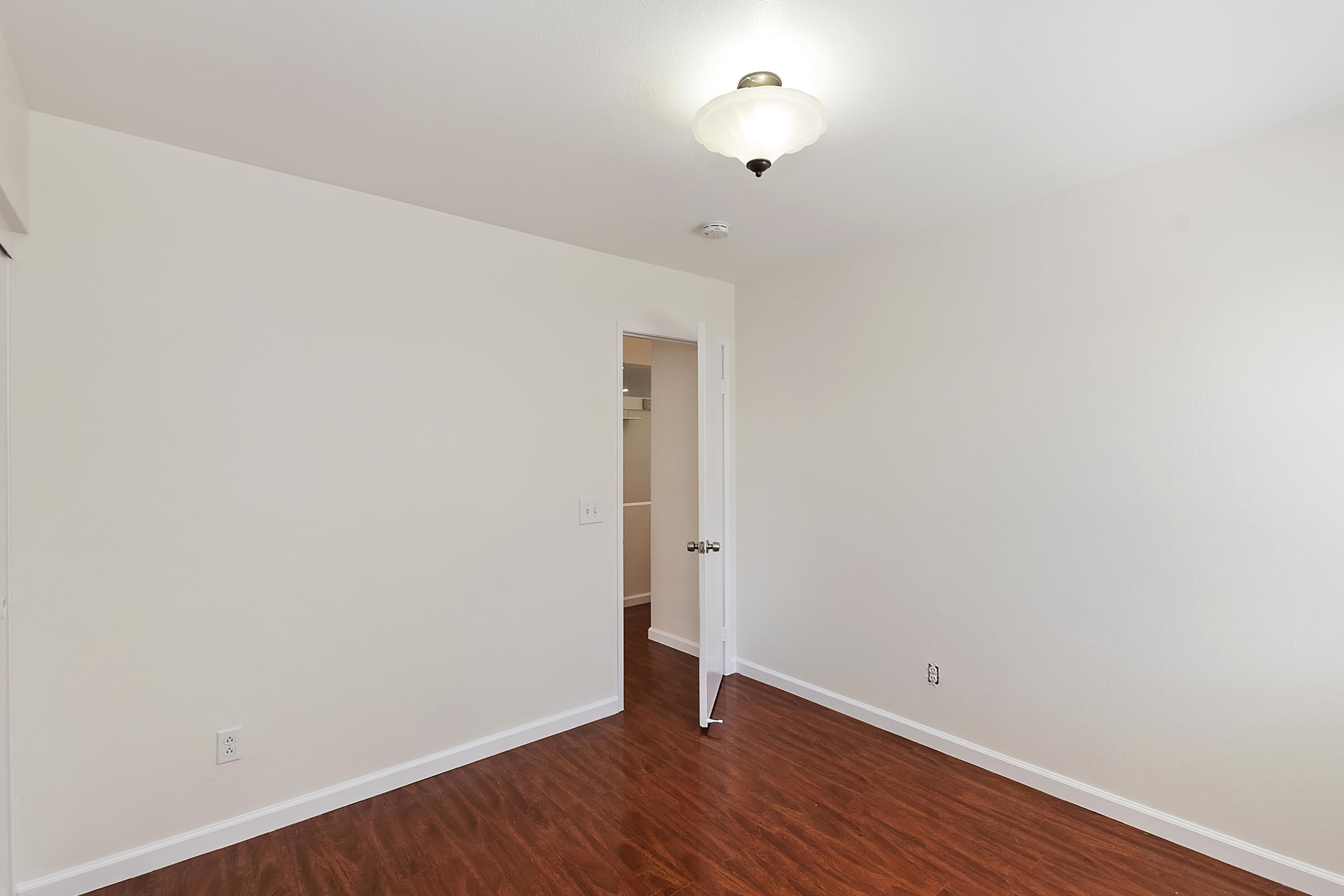 80472 Suncastle Road Indio, CA 92201 - Photo 23 of 32 a view of an empty room with wooden floor and a window