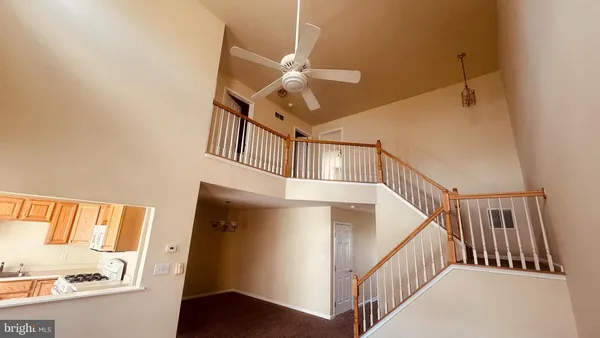 a view of staircase with railing and white walls