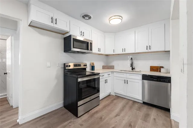 a kitchen with stainless steel appliances granite countertop a stove a sink and a microwave