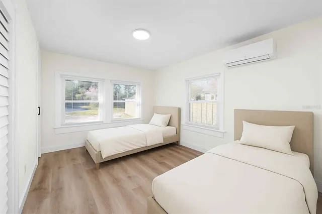 a bedroom with two beds and a window