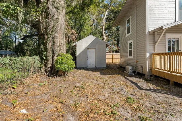 a backyard of a house with large trees and brick walls