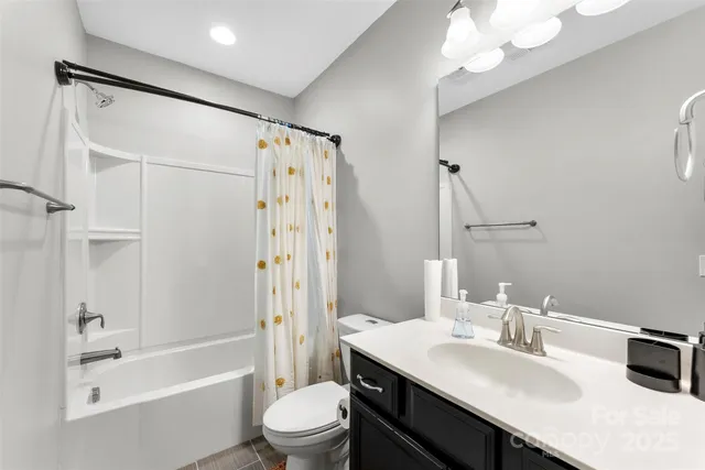 a bathroom with a sink a toilet a mirror and shower