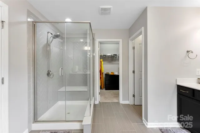 a bathroom with a glass shower door and a sink