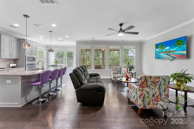 a living room with furniture a flat screen tv and a large window
