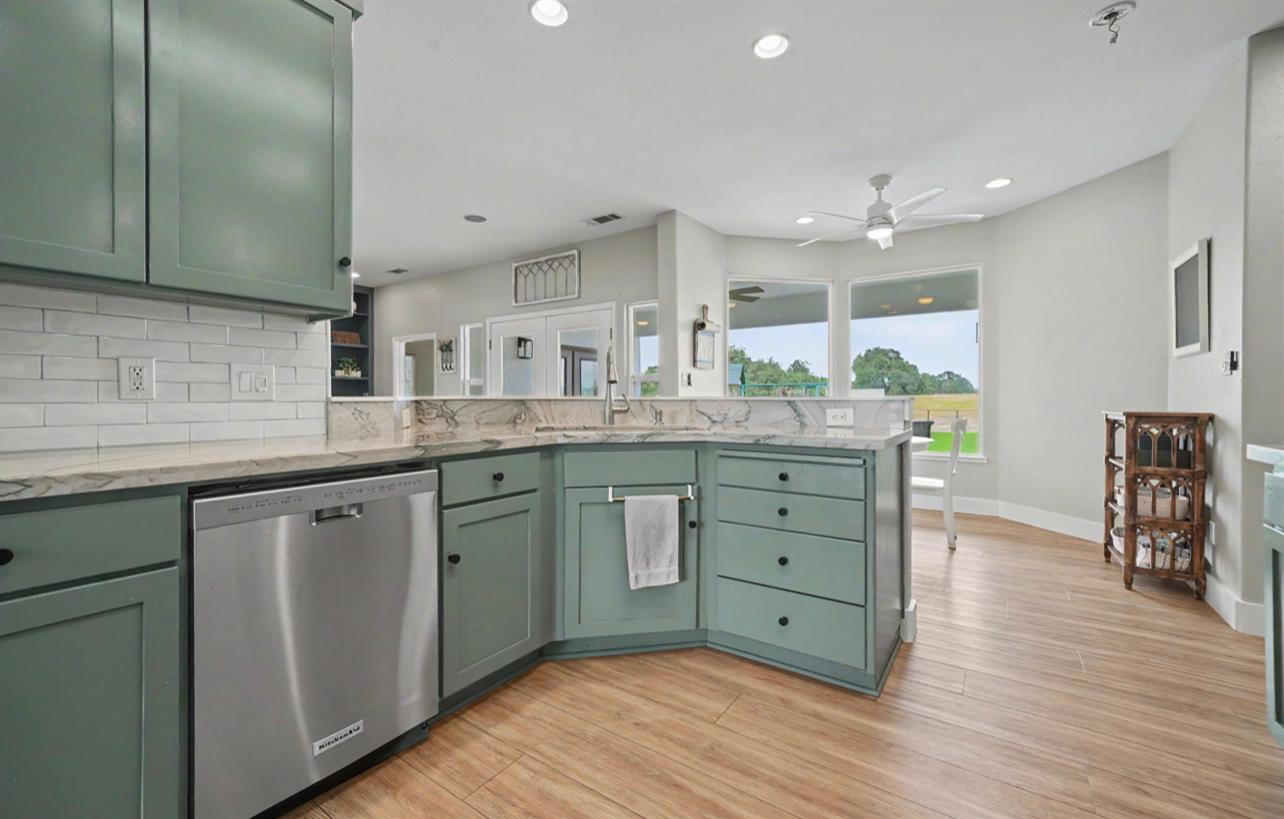 5600 Ferseyna Way Valley Springs, CA 95252 - Photo 59 of 94 a kitchen with stainless steel appliances granite countertop a sink cabinets and wooden floor