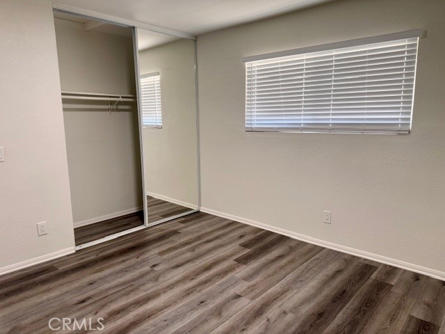 73740 Santa Rosa Way, Unit E Palm Desert, CA 92260 - Photo 8 of 15 a view of an empty room with wooden floor and a window