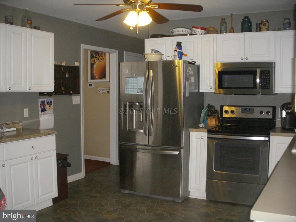 7674 Bethel Road Willards, MD 21874 - Photo 3 of 11 a kitchen with stainless steel appliances granite countertop a refrigerator a stove and a sink