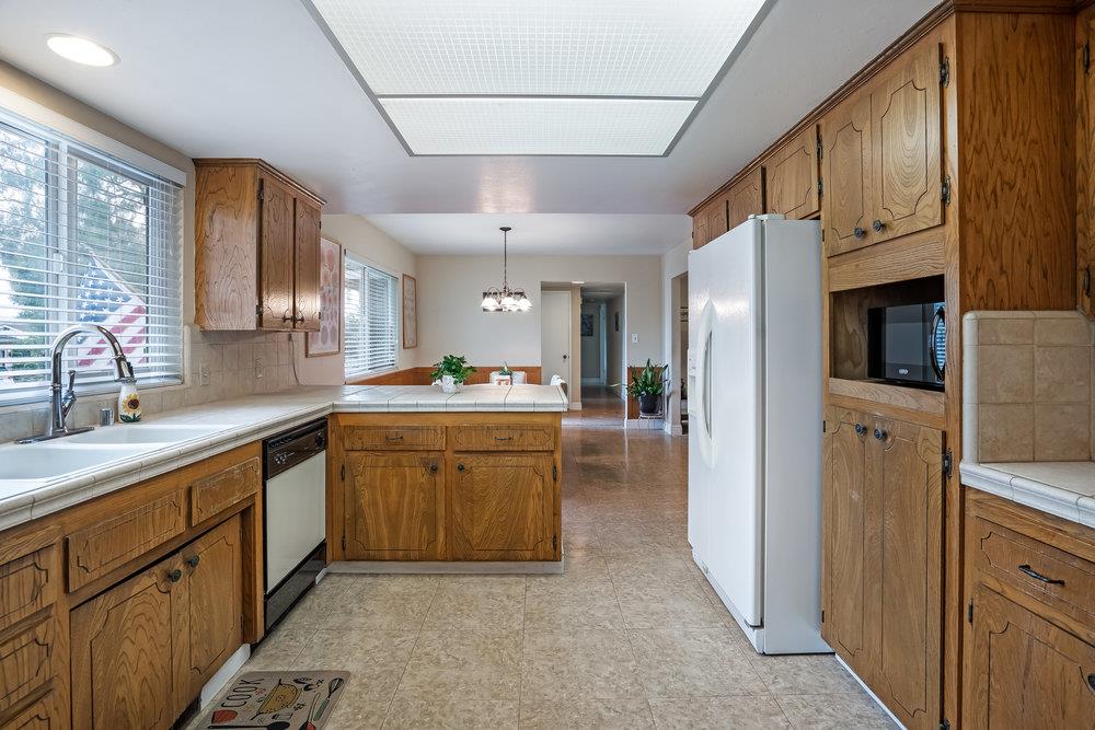 140 Rays Circle Hollister, CA 95023 - Photo 11 of 31 a kitchen with stainless steel appliances granite countertop a refrigerator a sink dishwasher a oven with white cabinets and wooden floor