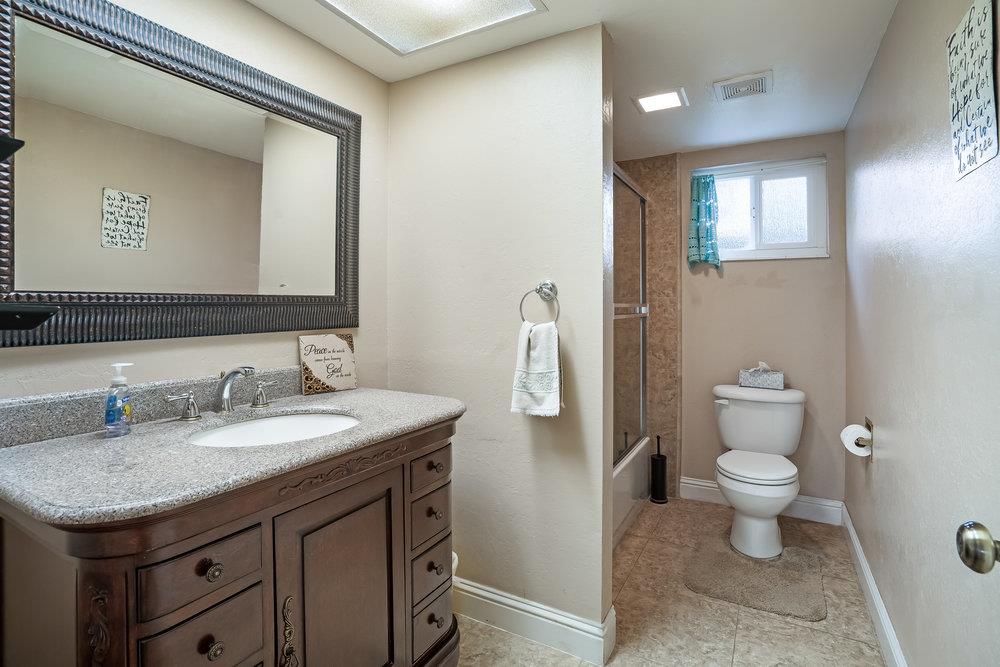 140 Rays Circle Hollister, CA 95023 - Photo 20 of 31 a bathroom with a granite countertop sink a toilet and a mirror
