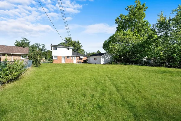 a view of a house with a big yard and potted plants