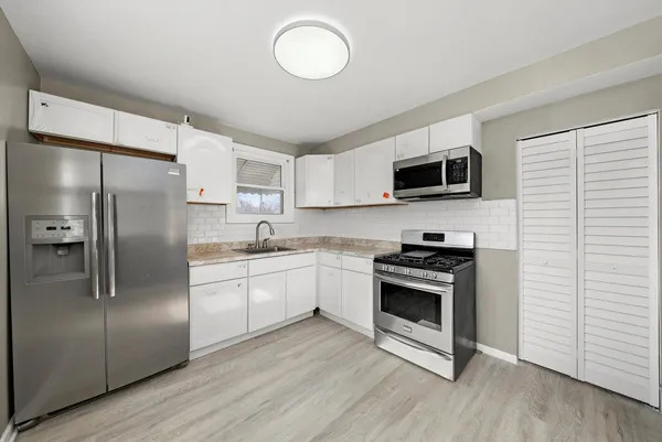 a kitchen with stainless steel appliances granite countertop a stove a sink and a refrigerator