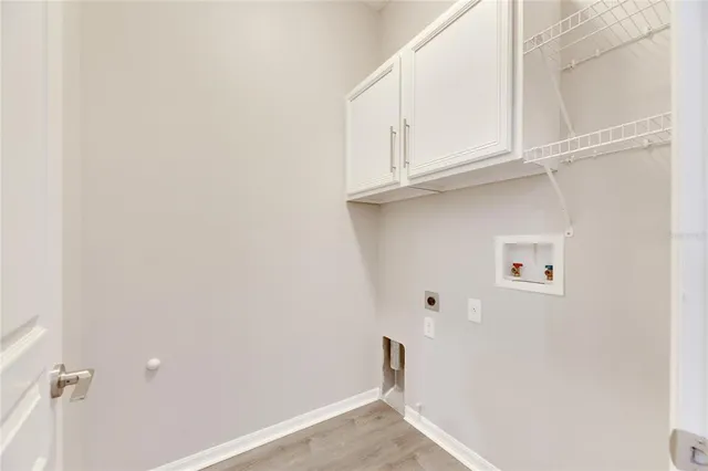 a spacious bedroom with a bed a chandelier and a large window