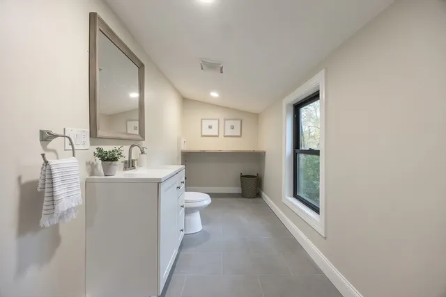 a spacious bathroom with a toilet sink and mirror