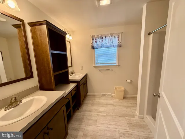 a bathroom with double vanity and a mirror