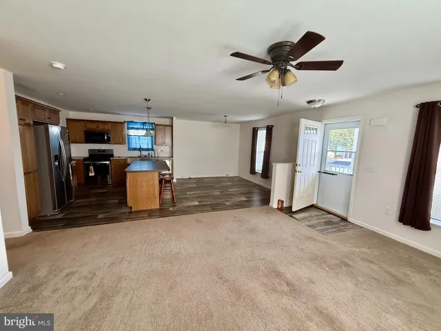 a view of empty room with window and refrigerator