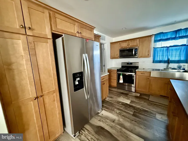 a kitchen with stainless steel appliances a refrigerator sink and microwave