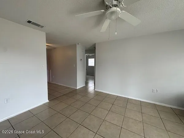an empty room with fan and entryway