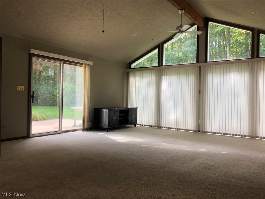 35236 Martin Road Willoughby, OH 44094 - Photo 21 of 35 Carpeted living room with vaulted ceiling with beams, a textured ceiling, a high ceiling, and ceiling fan