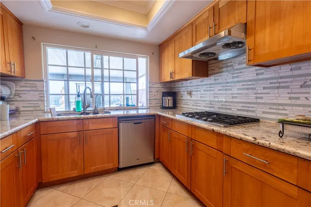 a kitchen with stainless steel appliances granite countertop a sink and a wooden cabinets