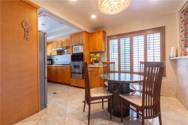 a dining room with stainless steel appliances a dining table and chairs
