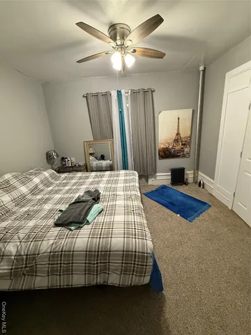 a bedroom with a bed and a mirror on the dresser