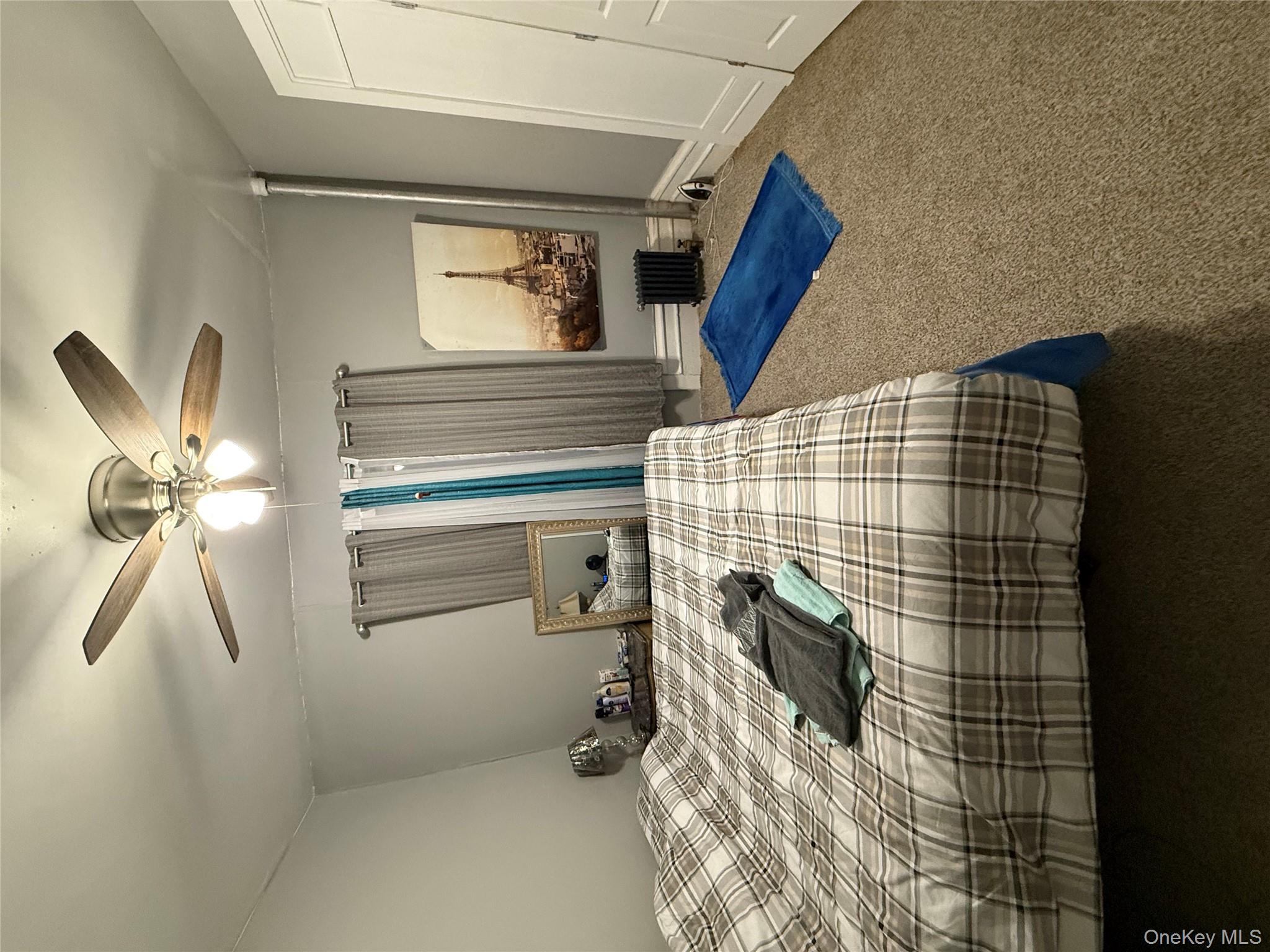 950 Hoe Avenue, Unit 4D Bronx, NY 10459 - Photo 5 of 8 a bedroom with a bed and a mirror on the dresser