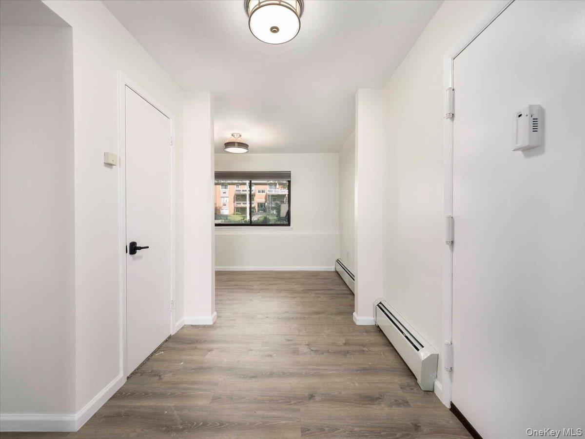 27 Tanager Road, Unit 2702 Monroe, NY 10950 - Photo 15 of 35 Entryway featuring light wood-finish flooring, white walls, flush-mount lighting, and baseboard heating