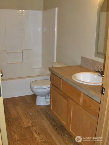 a bathroom with a granite countertop toilet and a sink