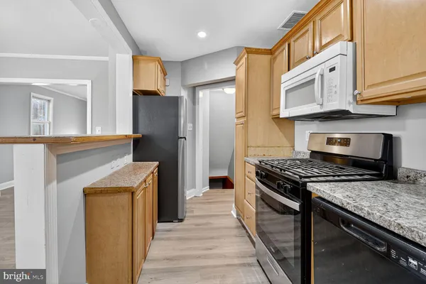a kitchen with stainless steel appliances granite countertop a stove and a refrigerator
