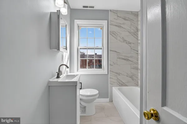 a bathroom with a sink a toilet and bathtub