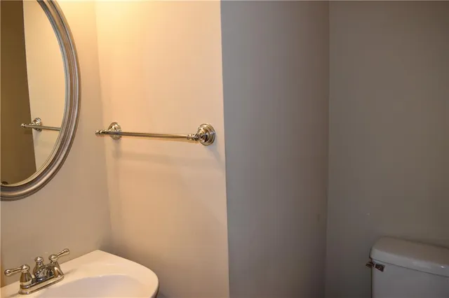 a bathroom with a toilet and a mirror