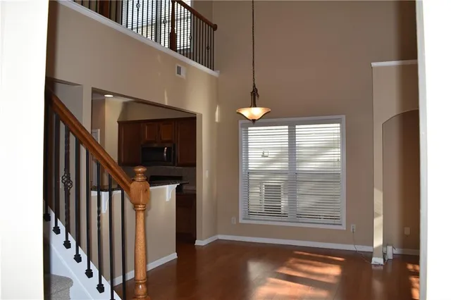 a view of hallway with stairs and wooden floor