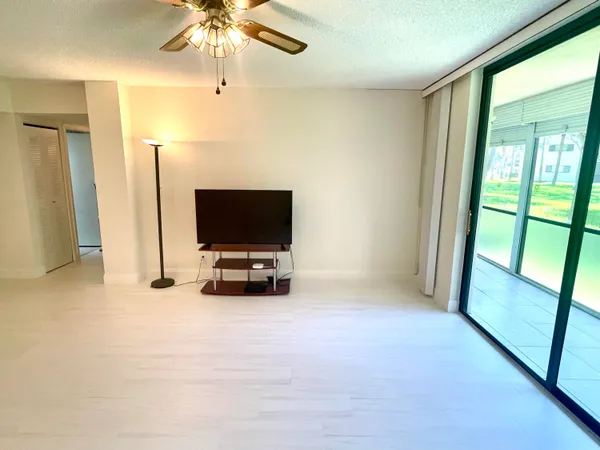 a view of a room with a flat screen tv and windows