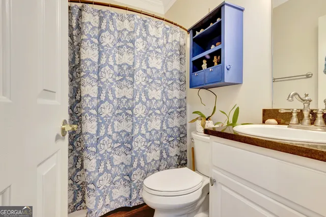 a bathroom with a toilet sink and mirror
